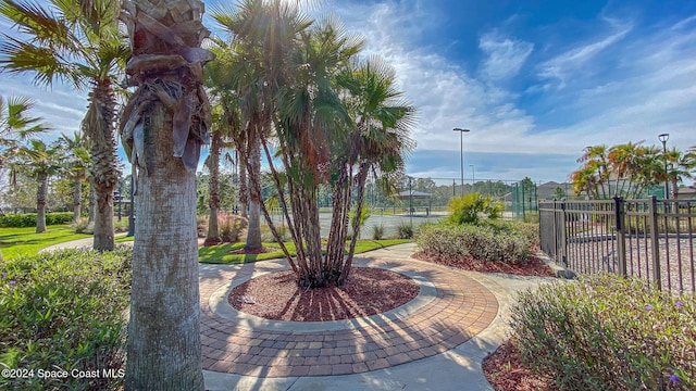 view of home's community featuring a water view and tennis court