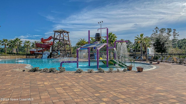 view of swimming pool featuring a playground and a water slide