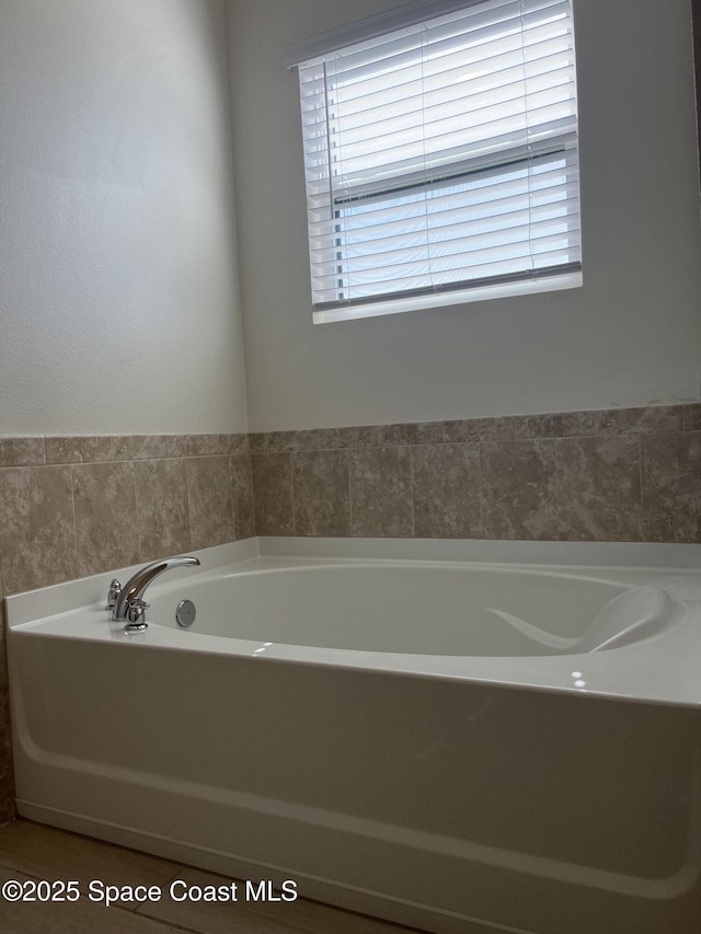 bathroom with tile patterned flooring, plenty of natural light, and a bath