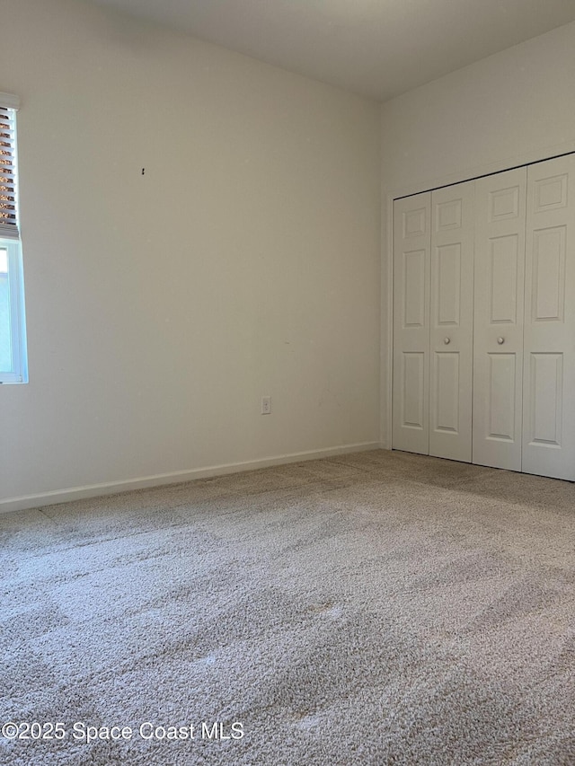 unfurnished bedroom featuring carpet floors and a closet