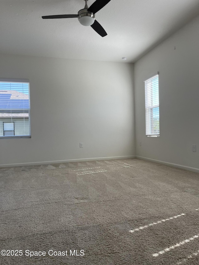 empty room featuring carpet, a healthy amount of sunlight, and ceiling fan