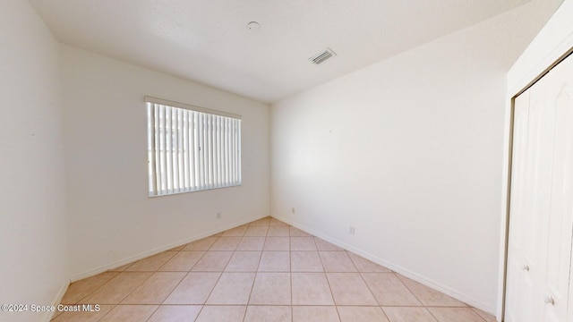 unfurnished room with light tile patterned flooring