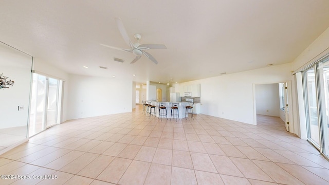 tiled spare room featuring plenty of natural light and ceiling fan