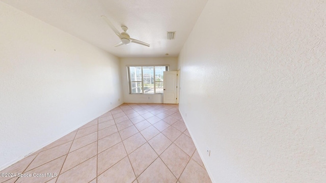 tiled spare room featuring ceiling fan