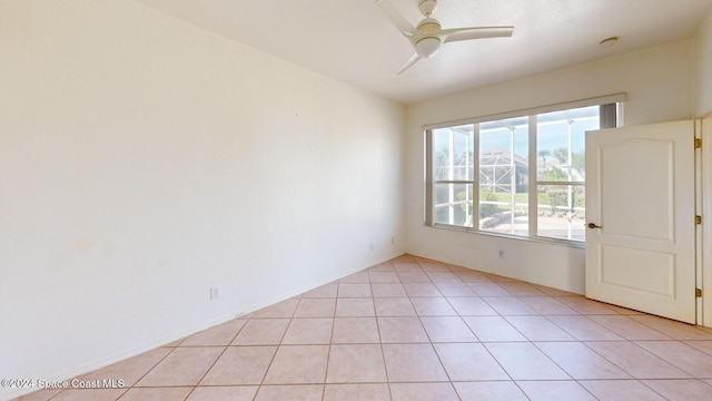 tiled empty room featuring ceiling fan