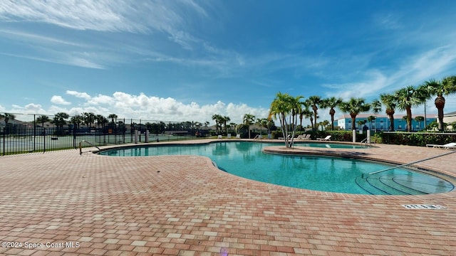 view of swimming pool featuring a jacuzzi and a patio