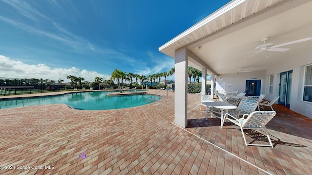 view of swimming pool with ceiling fan and a patio