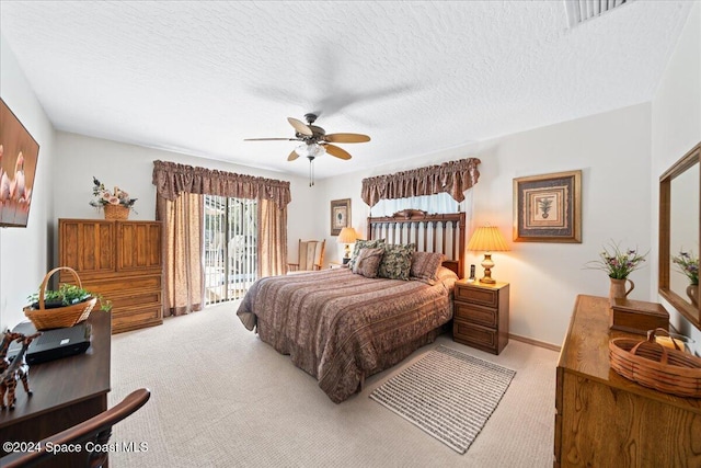 carpeted bedroom featuring access to exterior, a textured ceiling, and ceiling fan