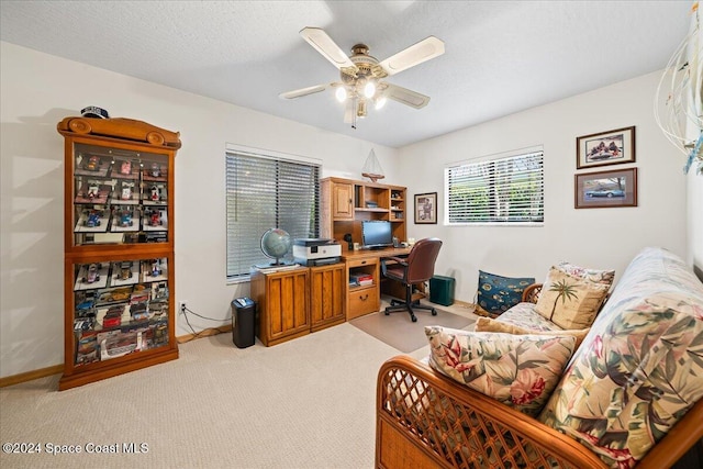 home office featuring ceiling fan, light colored carpet, and a textured ceiling