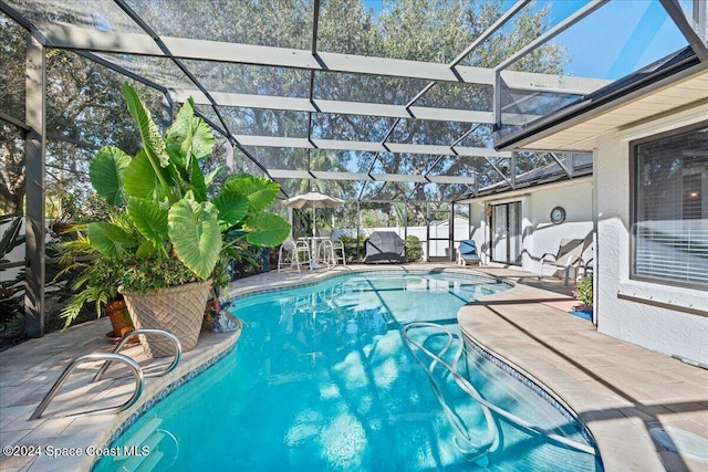 view of swimming pool with a patio and a lanai