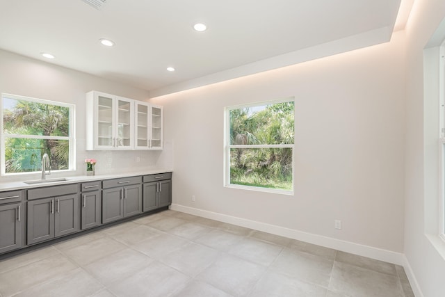 kitchen featuring white cabinets, gray cabinets, a wealth of natural light, and sink