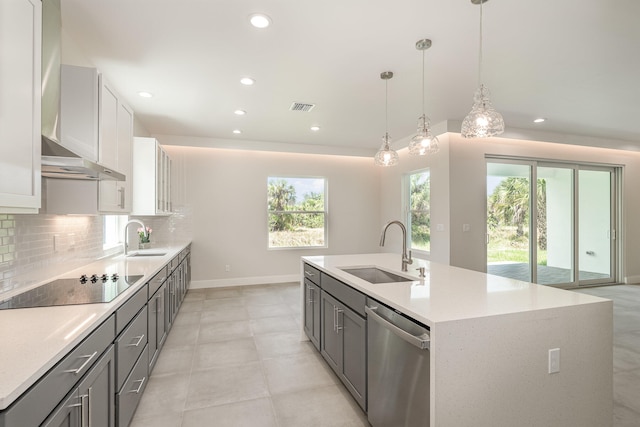 kitchen featuring black electric cooktop, sink, dishwasher, white cabinets, and plenty of natural light