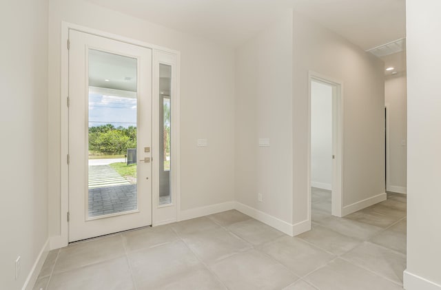 doorway to outside with light tile patterned floors