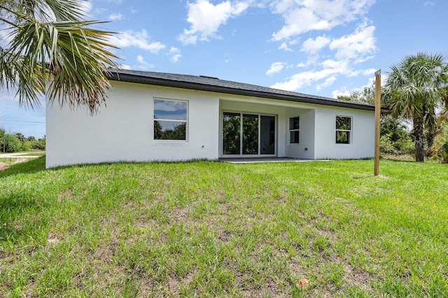 back of house featuring a patio area and a lawn