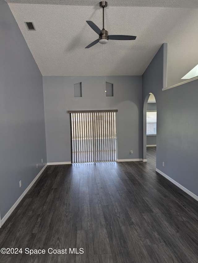 spare room with dark hardwood / wood-style floors, ceiling fan, lofted ceiling, and a textured ceiling