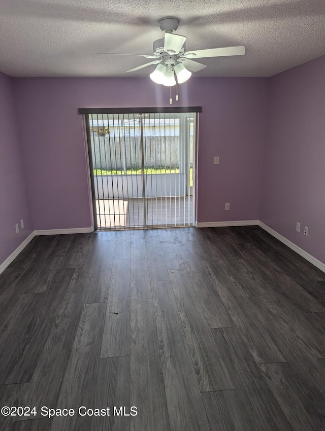 spare room with a textured ceiling, ceiling fan, and dark wood-type flooring