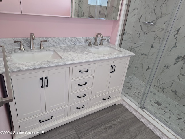 bathroom with wood-type flooring, vanity, and an enclosed shower