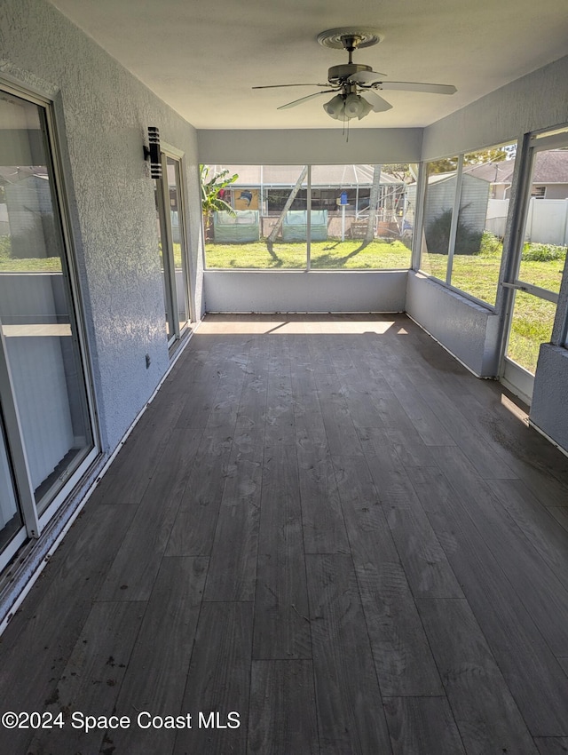 unfurnished sunroom featuring ceiling fan