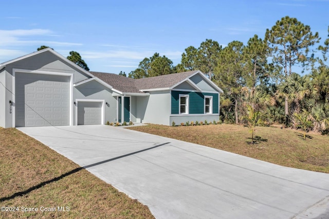 ranch-style home featuring a garage and a front lawn