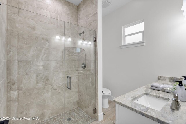 bathroom with vanity, toilet, and an enclosed shower