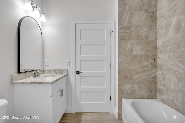 bathroom featuring vanity, wood-type flooring, and toilet