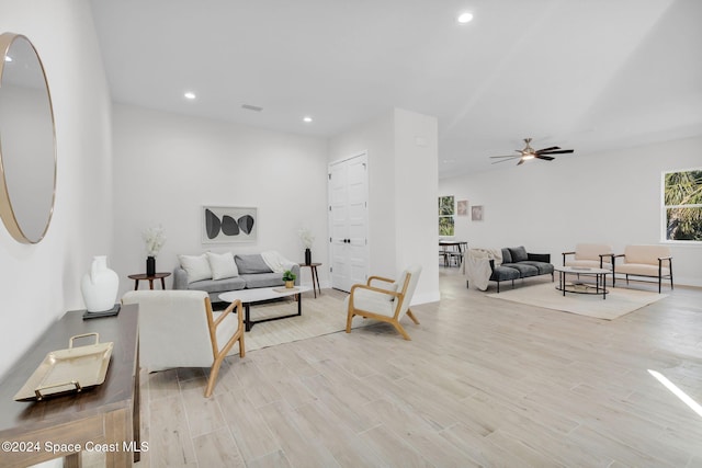 living room with ceiling fan and light hardwood / wood-style flooring