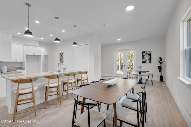 dining space with light hardwood / wood-style floors and sink