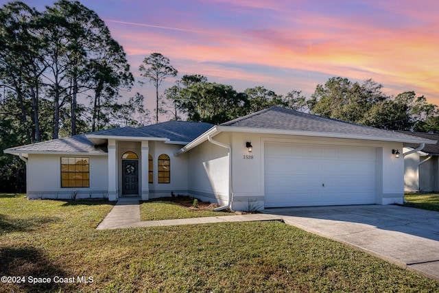 ranch-style home with a lawn and a garage