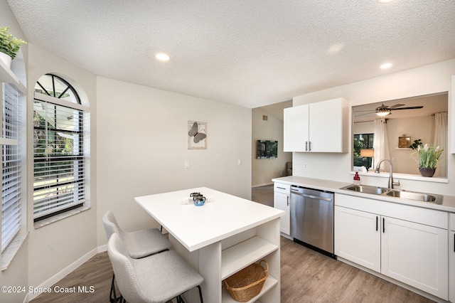 kitchen featuring a center island, dishwasher, sink, and white cabinets