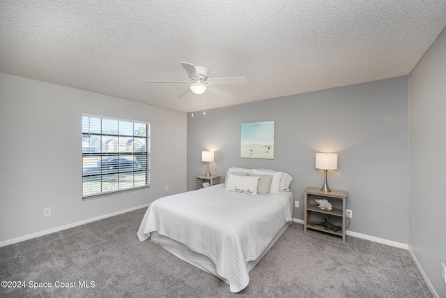 carpeted bedroom with ceiling fan and a textured ceiling