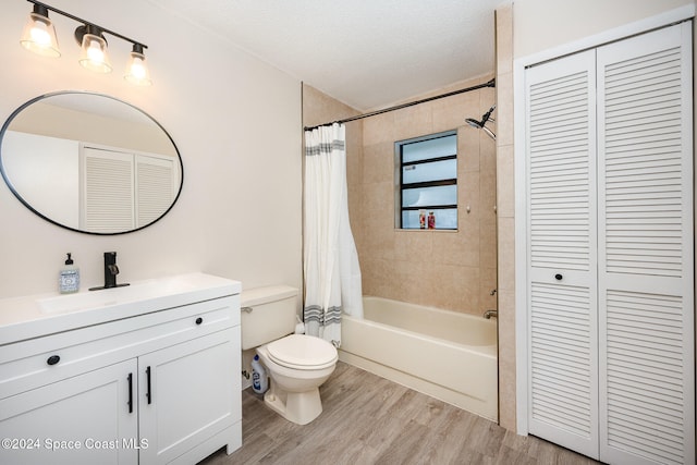 full bathroom featuring vanity, hardwood / wood-style flooring, toilet, a textured ceiling, and shower / tub combo with curtain