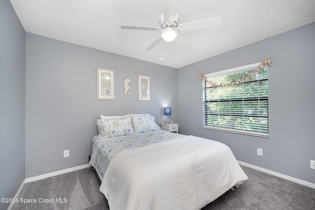 carpeted bedroom with ceiling fan and a textured ceiling