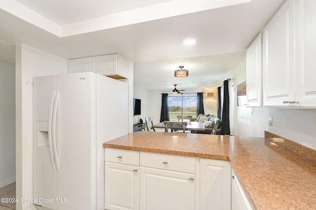 kitchen featuring ceiling fan, white cabinets, and white refrigerator with ice dispenser