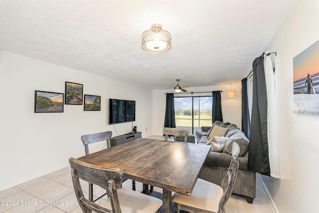 dining space featuring ceiling fan, light tile patterned flooring, and a textured ceiling