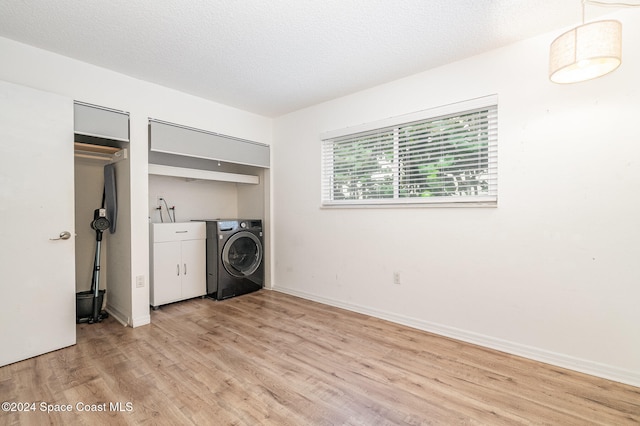 washroom featuring a textured ceiling, washer / clothes dryer, and light hardwood / wood-style floors