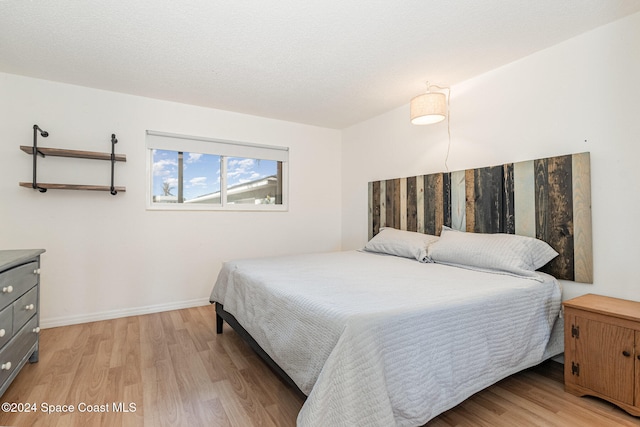 bedroom with light hardwood / wood-style floors and a textured ceiling