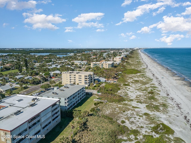 birds eye view of property with a water view and a beach view