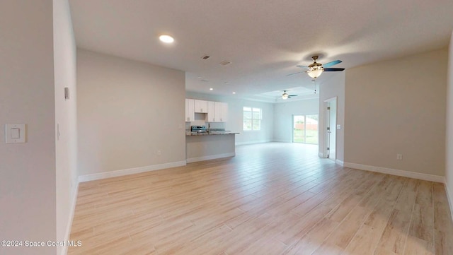 unfurnished living room featuring light hardwood / wood-style floors and ceiling fan