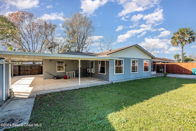 rear view of property with a patio area, a yard, and central AC