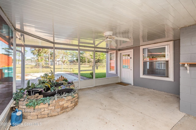 unfurnished sunroom featuring ceiling fan