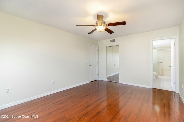 unfurnished bedroom featuring dark hardwood / wood-style floors, ceiling fan, and ensuite bathroom