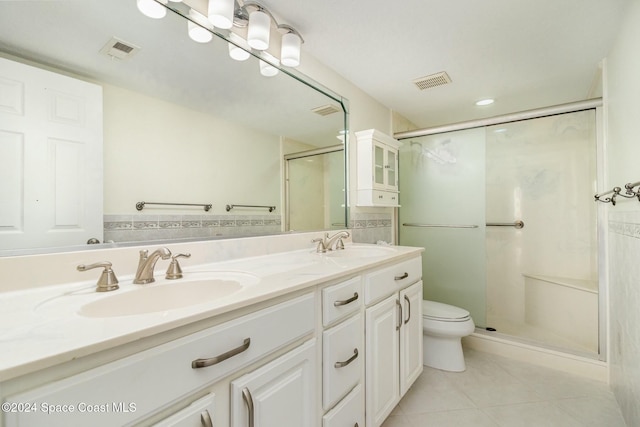 bathroom with tile patterned floors, vanity, an enclosed shower, and toilet