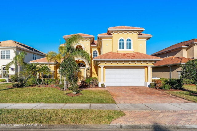 mediterranean / spanish house with a front lawn and a garage