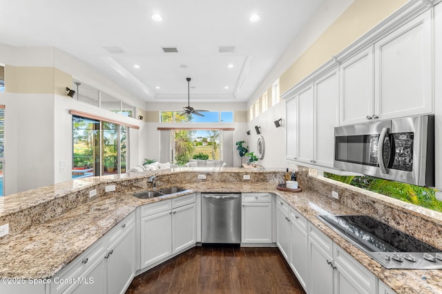 kitchen featuring a tray ceiling, white cabinetry, and appliances with stainless steel finishes