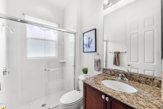 bathroom featuring vanity, toilet, and walk in shower