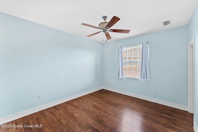 spare room featuring ceiling fan and dark hardwood / wood-style floors