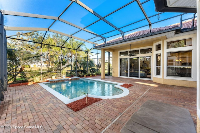 view of swimming pool featuring glass enclosure, ceiling fan, and a patio