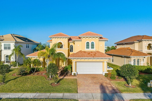 mediterranean / spanish home with a front yard and a garage