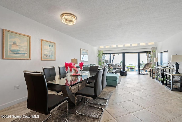 dining space featuring light tile patterned floors and a textured ceiling