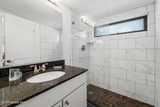 bathroom featuring a tile shower and vanity